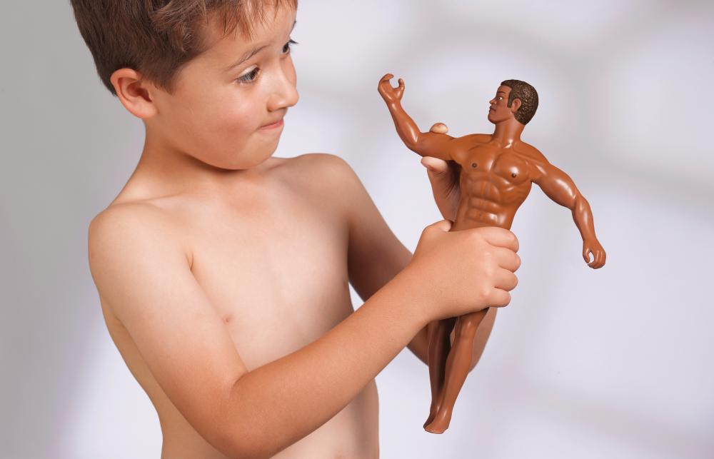A young boy comparing his muscles to his toy doll